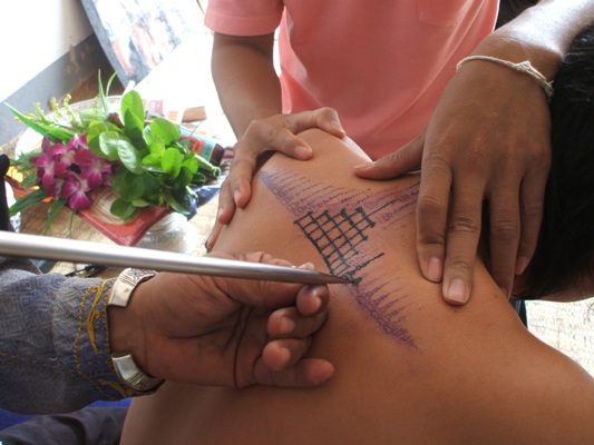 Ajarn Bunmee tattooing sak yant - apart from tattooing in kalasin in the Isan country he also travels around visiting Looksit around Thailand and tattoing them in their homes