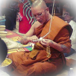 Luang Por Chanai is preparing white cords (Sinjana cords) for an amulet empowerment/Buddha Abhiseka.