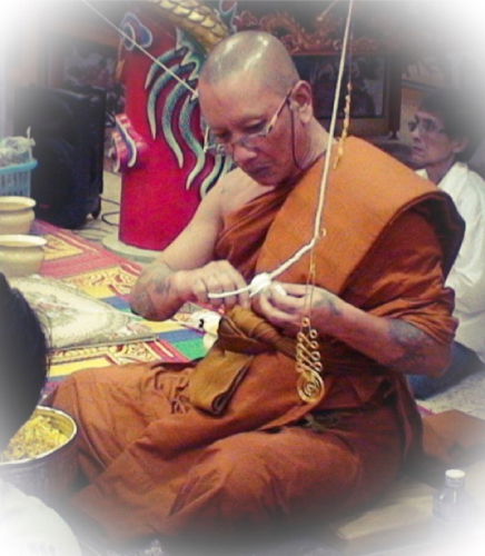 Luang Por Chanai is preparing white cords (Sinjana cords) for an amulet empowerment/Buddha Abhiseka.