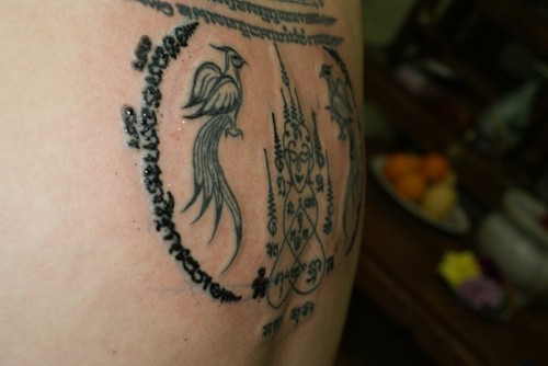 A Buddha Image (Ongk Pra) is flanked by a Heavenly Bird
